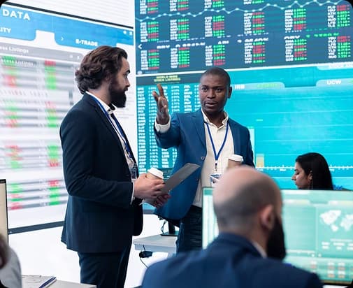 Colleagues discussing market data on a trading floor