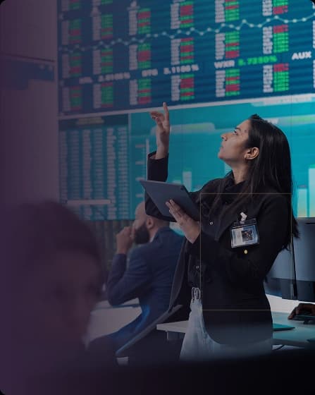 Analyst reviewing live market data on trading floor screens